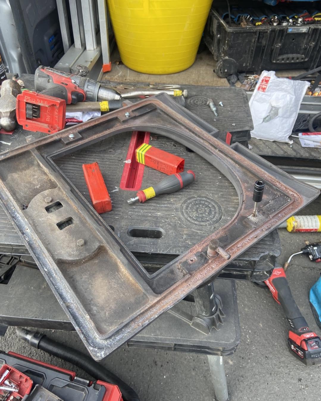 A stove door frame stripped down on the bench during a repair