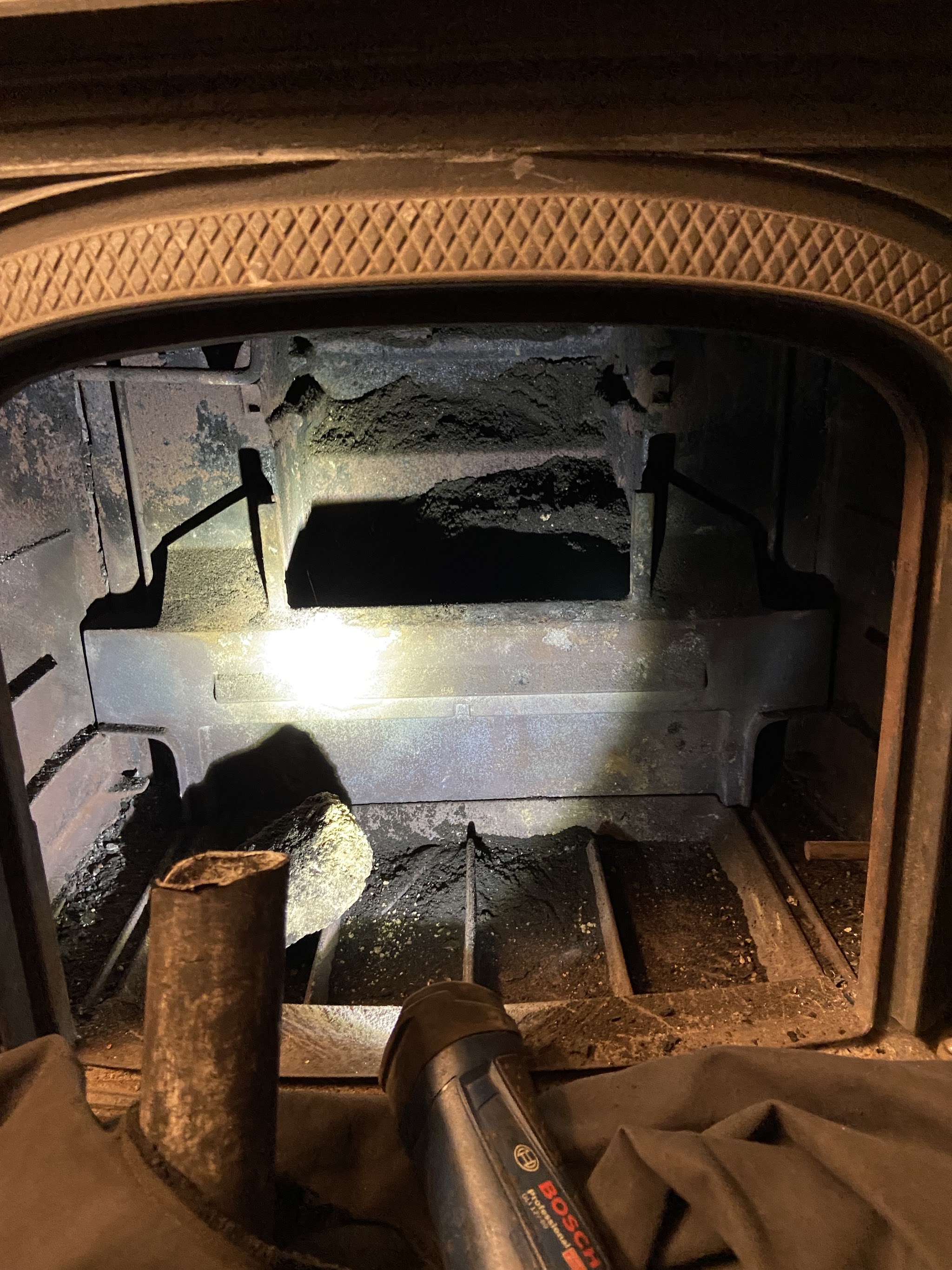 Inside a stove firebox, lit by a torch during an inspection